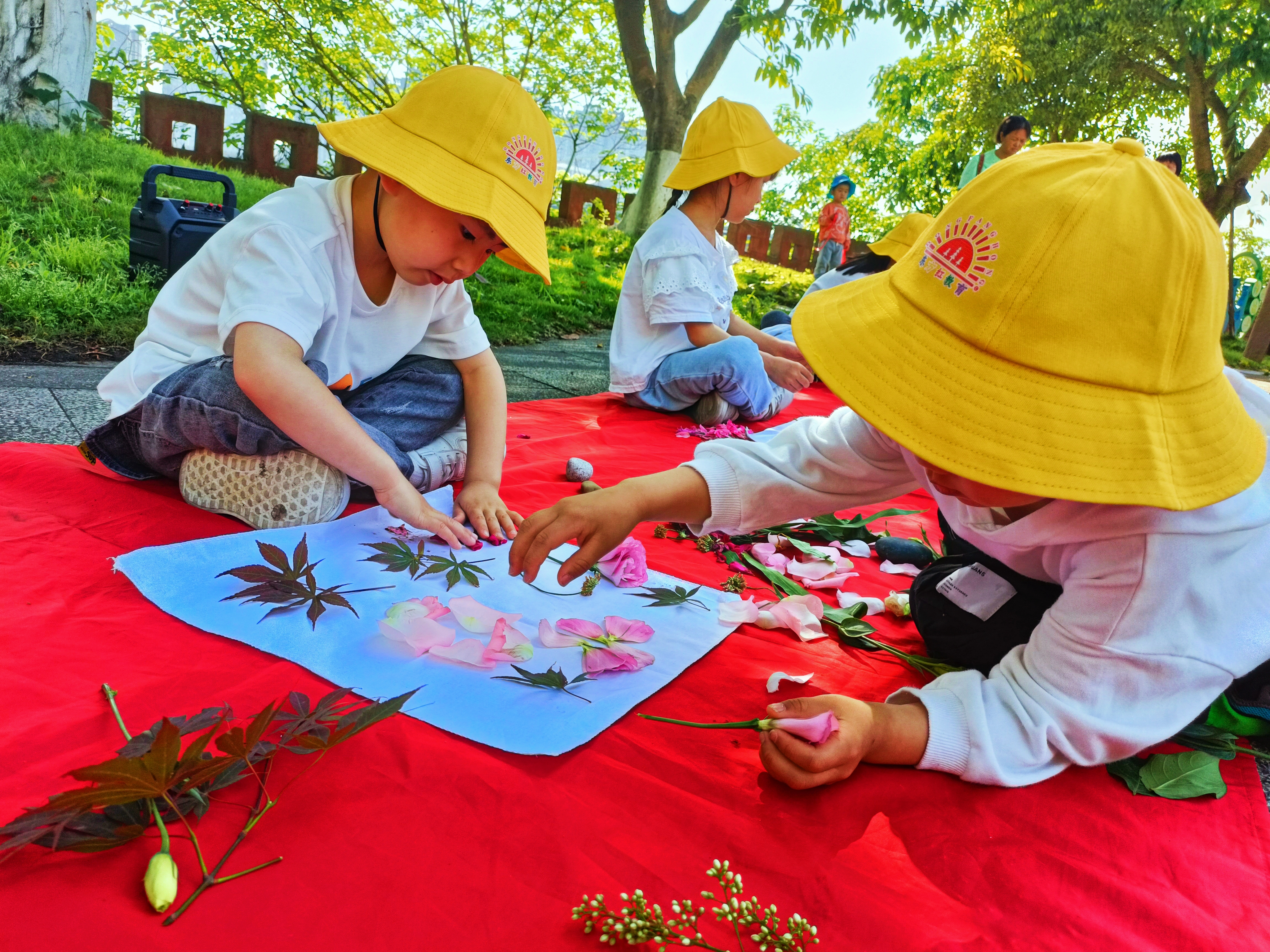 4月26日上午,嘉樂幼兒園大二班孩子在老師的帶領下用植物敲拓染的新奇